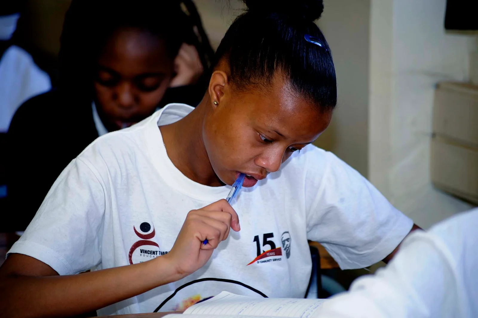 A learner concentrating on her work in the classroom